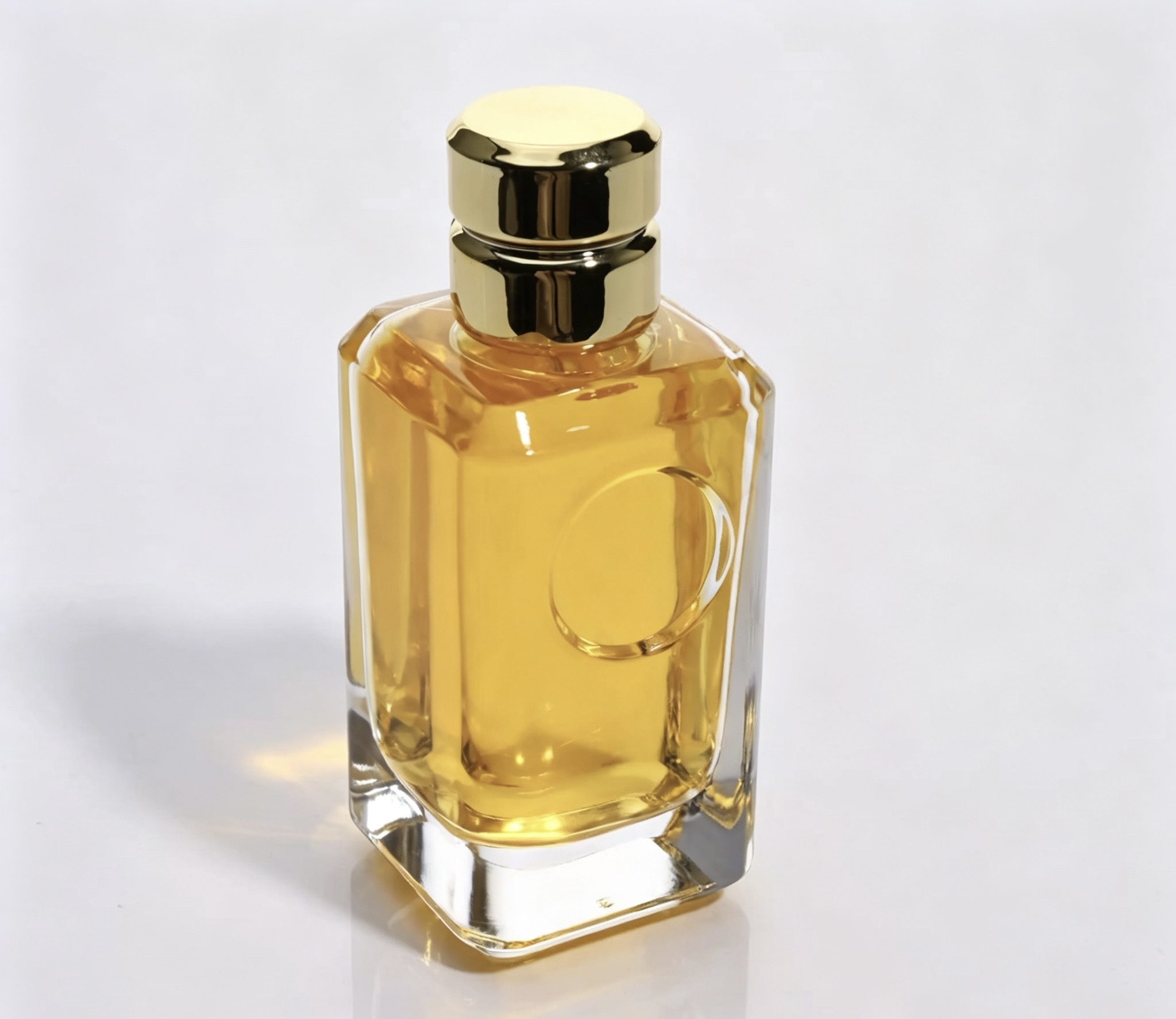 Clear square perfume bottle with a polished gold cylindrical cap