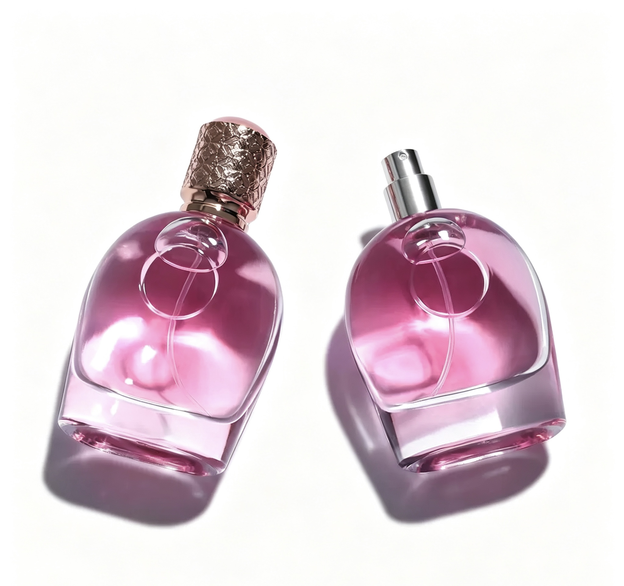 Pair of rounded pink glass perfume bottles with decorative caps
